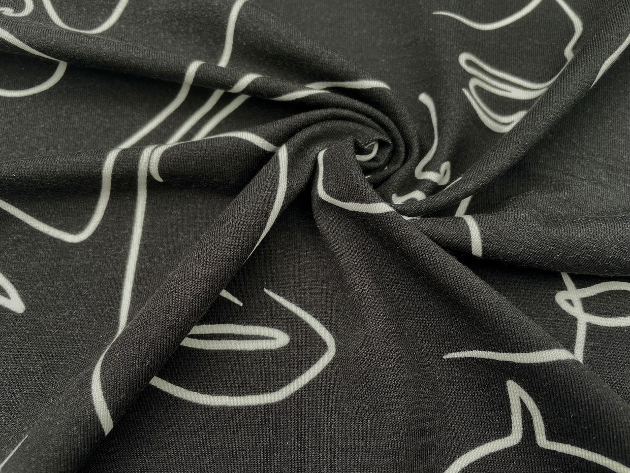 Tencel Jersey "Faces" Schwarz Reststück 120cm x 150cm